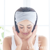 一位女性戴著灰色純棉吸水髮巾，頭髮向後梳，雙手輕觸臉頰。