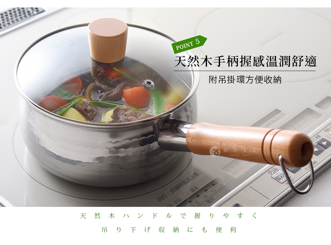 一款帶有透明鍋蓋的不鏽鋼雪平鍋置於電磁爐上，鍋身表面具有錘目紋理，木質把手觸感溫潤舒適，末端附有金屬吊掛環便於懸掛收納，鍋內正燉煮著蔬菜與肉類料理。