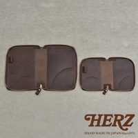 兩個棕色皮革製的拉鍊式收納包，分別為較大和較小的尺寸，內側有夾層和筆插，底部有品牌Logo。