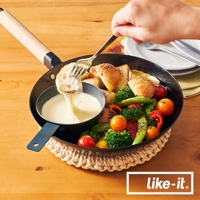 黑色鐵製調理鍋，配有木製手柄，鍋內盛有起司醬，旁邊是烤蔬菜和麵包塊，由叉子夾取一片沾有起司的麵包。