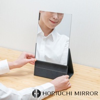 NAPURE 桌上型2Way折疊化妝鏡，黑色外框，鏡面光滑，可折疊立於桌面，呈現女性臉部倒影。