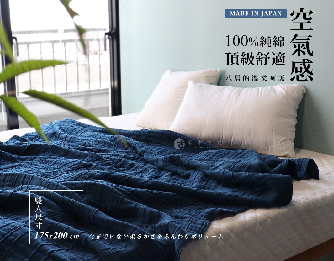 深藍色八層紗雙人透氣被，100%純棉材質，觸感柔軟，尺寸為 175x200 cm，蓋在鋪有白色床單的雙人床上，旁邊有兩個白色枕頭。