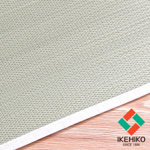 藺草編織枕墊，淺綠色，紋理清晰，邊緣有白色滾邊，下方為木紋背景。