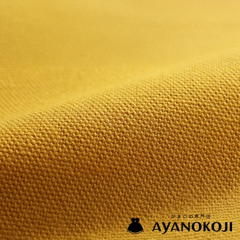 模式B： 金黃色斜紋布料特寫，布料表面有細緻紋理，下方有 AYANOKOJI 品牌標誌