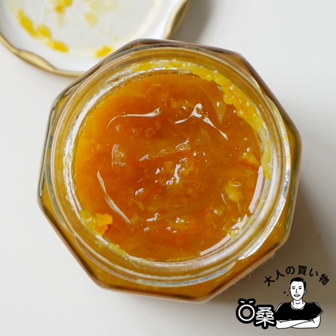 盛裝於玻璃瓶中的和歌山有田柑橘果醬，果醬呈現鮮豔的橘黃色，質地濃稠，可見細小的果皮絲。瓶蓋部分可見金屬材質。