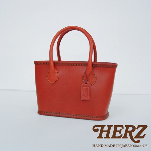 職人手作皮革散步手提包 Q-1，橘紅色，精緻車縫線，附有品牌皮革吊牌。