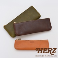 職人手作皮革經典收納筆袋，展現三款顏色：墨綠、咖啡色、棕褐色。筆袋均採用細緻皮革材質，搭配精緻縫線與金色拉鍊，展現質感。