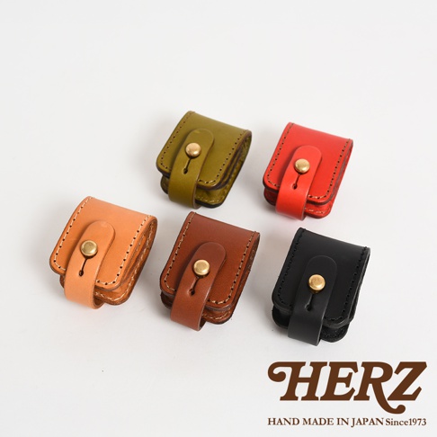 五個皮革製的腰間小物收納包，分別為橘棕、深棕、墨綠、亮紅和黑色，皆採用原子釦設計，手工縫製，質感樸實。