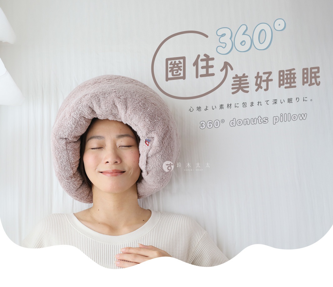 一位女性戴著粉色絨毛材質的甜甜圈造型枕頭，枕頭包裹住她的頭部。