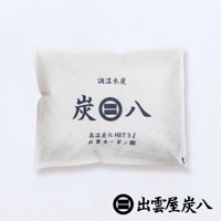 白色無紡布包裝，內含黑色調濕木炭。包裝正面印有深藍色日文「調濕木炭」和「炭八」字樣，以及「高温炭化 NET 3ℓ 出雲カーポン(株)」。底部有品牌標誌和日文「出雲屋炭八」。
