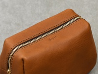 職人手作皮革Organ拉鍊收納包，M尺寸，採用棕褐色皮革製成，配有金色拉鍊和縫線細節。