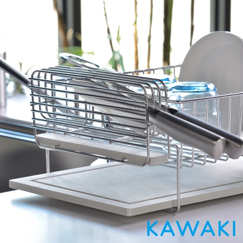 銀色金屬網架，內含珪藻土吸水板，架上放置兩支不鏽鋼刀具，後方有藍色玻璃杯及白色盤子。