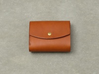 職人手作皮革Organ迷你短夾，採用溫潤的棕色皮革製成，設有金屬按扣，設計簡潔實用。