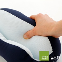 深藍色與淺藍色網眼布料拼接的舒眼枕，一隻手正按壓其柔軟的填充物，展現產品的舒適觸感。