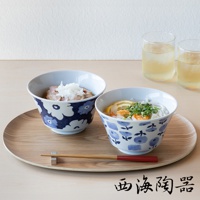 兩個藍色花紋的兩件式丼飯碗，盛有日式料理，置於木質托盤上，旁有兩杯飲品。