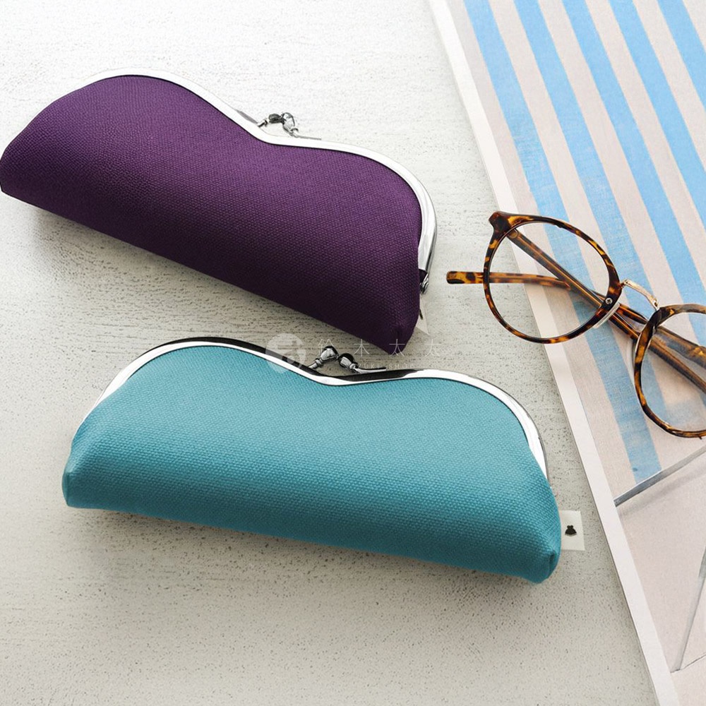 紫色和藍綠色口金眼鏡盒，旁邊放著一副玳瑁紋路的眼鏡