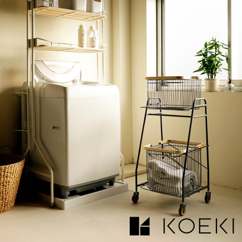 Mash移動式雙層分類洗衣置物籃，黑色金屬框架搭配木質提把，兩個網狀籃筐，下方籃筐內有衣物。