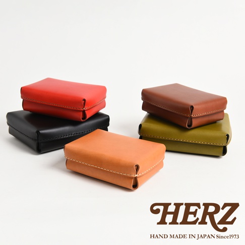 職人手作皮革小物收納盒，展示紅、黑、棕、綠、橘共五種顏色。盒身為方形，以皮革材質製作，邊緣有縫線裝飾，設計簡潔。