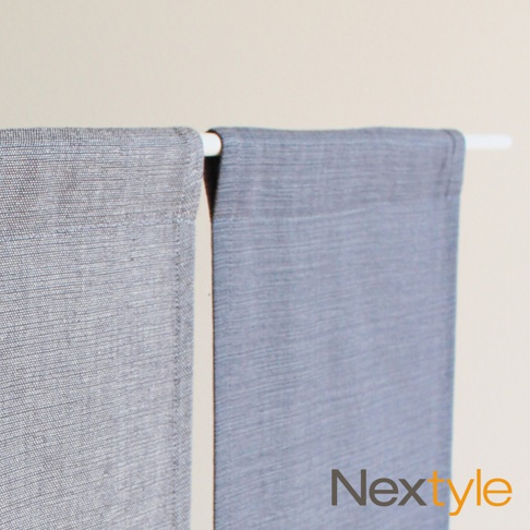 兩片淺灰藍色布簾，材質為織布，分別掛在白色桿子上。左側布簾紋理較細緻，右側布簾紋理較粗。