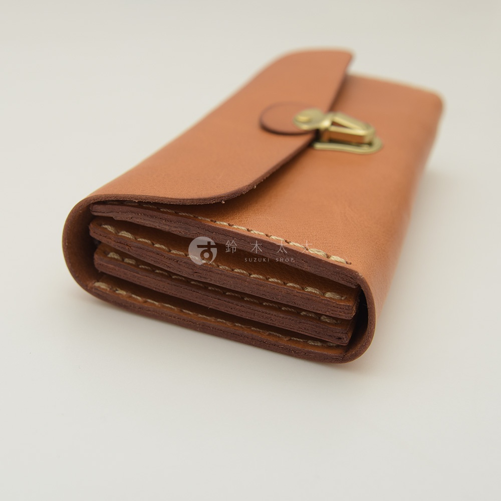 棕褐色皮革製成的手風琴式多卡層長夾，帶有復古金屬鎖扣，手工縫線清晰可見。