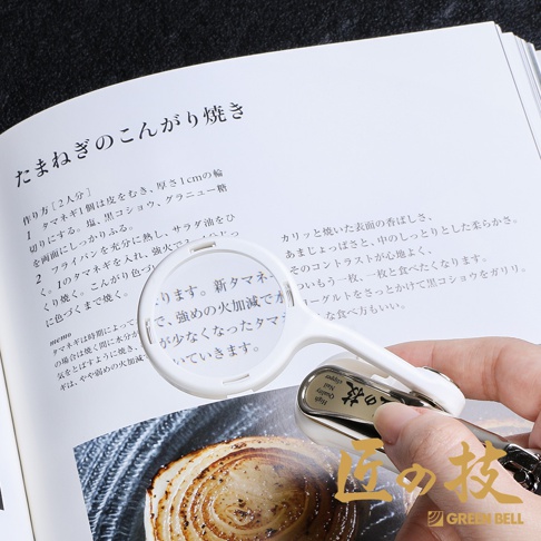 白色不鏽鋼附放大鏡指甲剪，具有放大鏡和指甲剪的組合設計，鏡片清晰，剪刀部分為金屬材質，帶有英文標示。