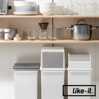 三個白色搖蓋式高版垃圾桶，其中兩個帶有灰色頂蓋，分別置於廚房架下方的白色檯面上。