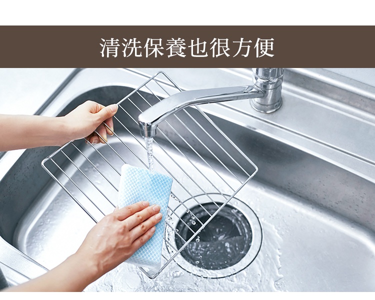 雙手正在水槽中清洗一個不鏽鋼烤架，烤架表面有水滴。