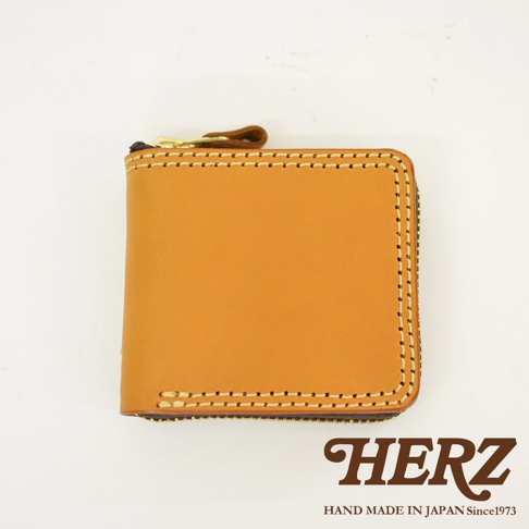 日本品牌HERZ職人手作皮革全包式拉鍊短夾，選用淺棕色Latigo軟皮革製作，展現扎實的車縫線細節與簡約洗練的方正外型，右下角印有HERZ品牌字樣。