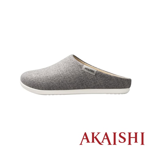一雙灰色織物材質的包覆式室內拖鞋，鞋面有「AKAISHI」品牌標籤，白色鞋底。