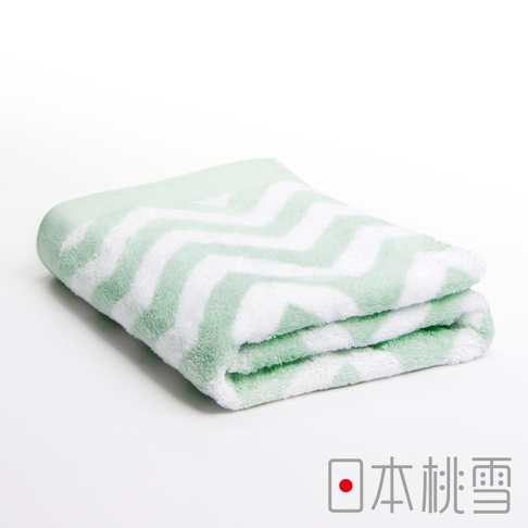 一條對折的今治北歐風格浴巾，採用淺綠色與白色相間的鋸齒形圖案，材質看起來柔軟。