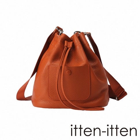 itten-itten 品牌橙色荔枝紋皮革束口水桶包，正面有翻蓋口袋和圓形按鈕。