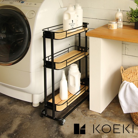 黑色三層置物夾縫式收納推車，搭配淺木色層板，附有滾輪，可收納洗衣精、噴瓶等居家用品。