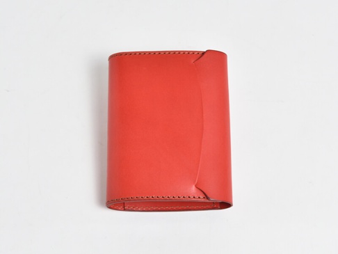 紅色皮革A6記事本書套，表面光滑，邊緣有縫線細節，設計簡潔，展現皮革質感。