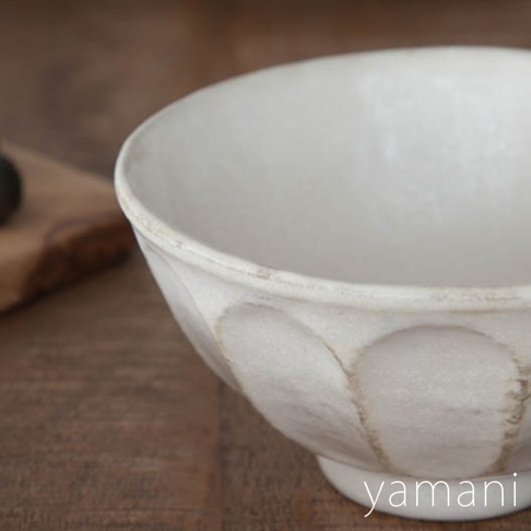 一個米白色、帶有六道凹凸紋理的陶瓷丼碗，碗身外側有自然的暈染痕跡，整體呈現樸實的質感。