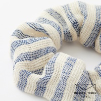 今治有機匹馬棉雙色彈力髮圈，織紋呈現奶油白與藍色細條紋，材質柔軟有彈性。