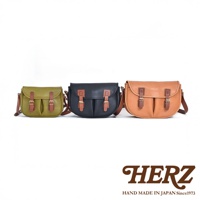 三款職人手作皮革傳統釣魚包，依序為橄欖綠、黑色和棕褐色，皆配有棕褐色皮革翻蓋和皮帶扣。