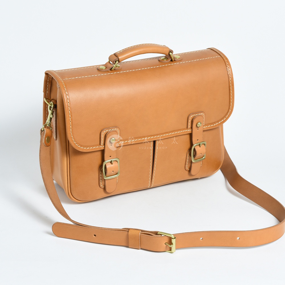 職人手作皮革單肩包，經典棕色，設計簡約，配有可調節肩帶和黃銅色金屬扣環，適合商務與休閒場合。