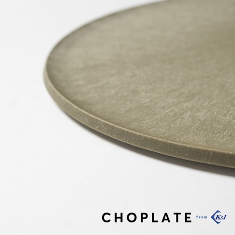 這是一張特寫鏡頭，展示了KAWABE CHOPLATE兩用砧板盤的邊緣細節。盤體呈現低調的霧面橄欖綠色澤，表面具有細緻的仿石材紋理，邊緣厚度平整且圓潤。畫面下方標註了CHOPLATE品牌名稱以及KSJ標誌，整潔地呈現了該產品輕量化且具備現代簡約美學的質感。
