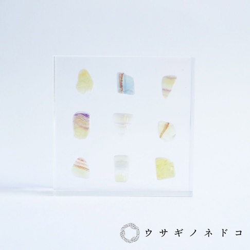 9塊方形透明壓克力板內嵌切片狀螢石標本，螢石呈現黃色、紫色、藍色及白色等漸層色澤。