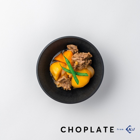 黑色CHOPLATE沙拉碗，盛裝著燉牛肉、馬鈴薯、紅蘿蔔塊及青豆。