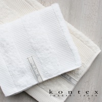 兩條 WAFFLE BORDER 今治雙織有機棉浴巾，一條為白色，另一條為米白色，皆為鬆餅紋織法，並有印有「Organic cotton 100%」字樣的標籤。