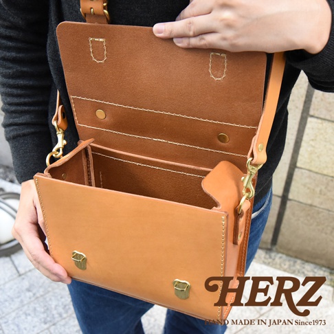 職人手作皮革極簡風兩用迷你單肩包，自然原色皮革，內外層皆有縫線細節，包身方形結構，配有金屬釦與皮質背帶，可單肩或斜背。