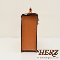 職人手作皮革機師箱，側視圖，呈現其堅挺的方形輪廓，棕褐色皮革材質，搭配金屬鎖扣，縫線整齊，風格簡約。