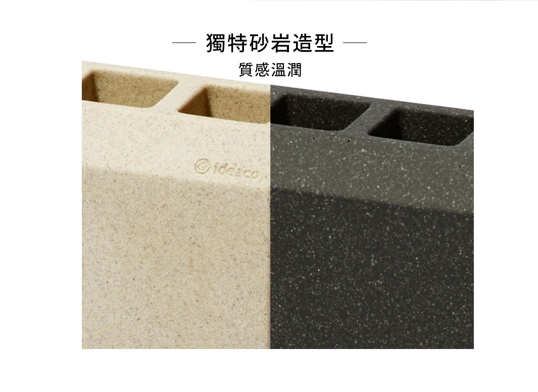 兩個砂岩製成的重型門擋，左側為米白色，右側為深灰色，均有五個方形開孔，表面帶有顆粒感。