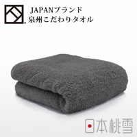 一件摺疊的深灰色加厚毛巾，質地柔軟蓬鬆，毛圈清晰可見。上方有日文品牌標誌。