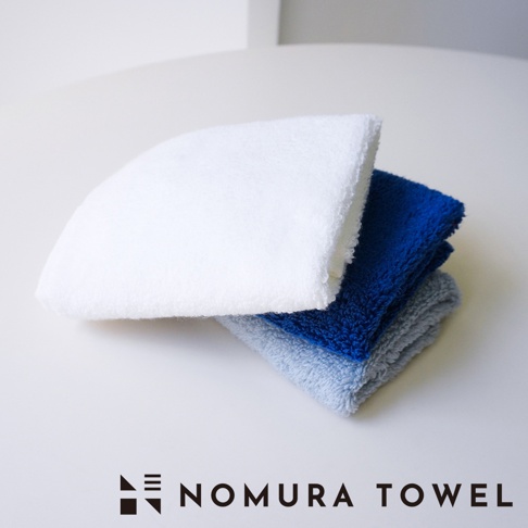 野村毛巾 SUUZO 超無撚極吸水方巾，疊放著白色、藍色和淺灰色三條毛巾。