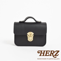 黑色皮革迷你收納包，配有金色金屬鎖扣和提把，簡潔的設計展現職人手作質感。