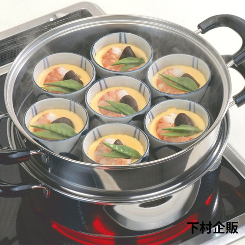 不鏽鋼雙層蒸氣料理鍋，內置七個裝有蒸蛋、蝦仁、香菇及豌豆的日式小碗，碗內有藍色條紋裝飾，鍋身有黑色把手，鍋底加熱紅色光芒。