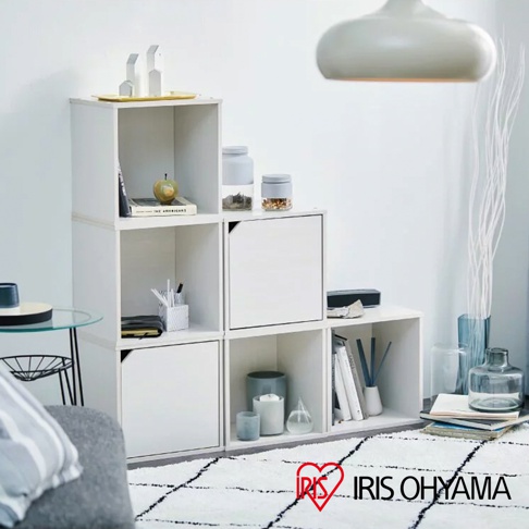 白色立方體附門組合收納櫃，層疊擺放，部分櫃門關閉，櫃內展示書籍、裝飾品及收納盒。