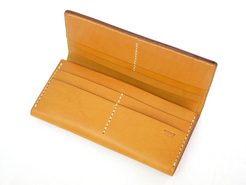 職人手作的棕色皮革長夾，內部有多個卡槽，縫線清晰。